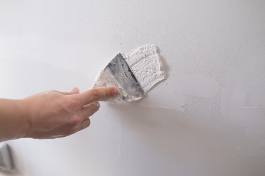 repairing walls with putty and spatula